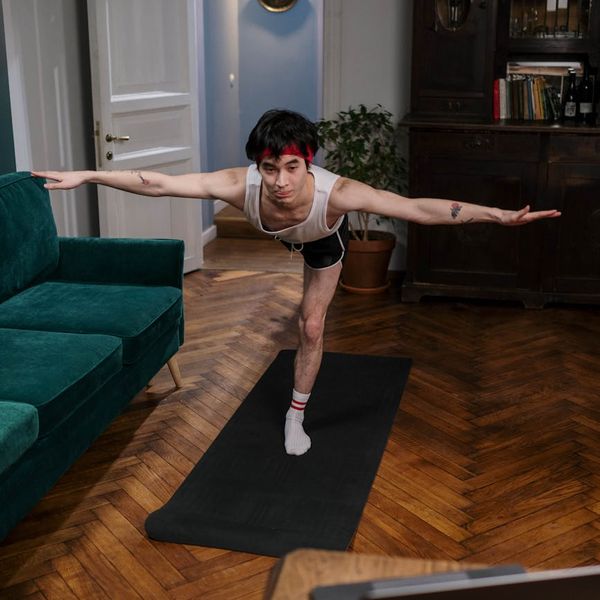 Man holding a difficult yoga arm balance pose showing strength.
